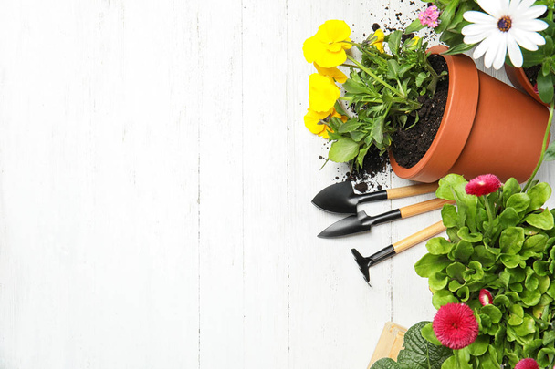 Composition with gardening equipment and flowers on wooden table, top view - Fotó, kép
