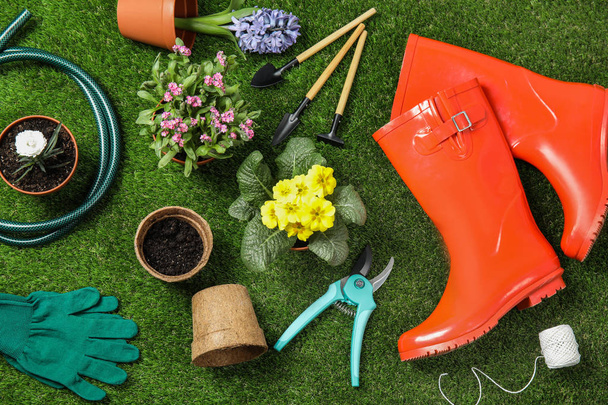 Flat lay composition with gardening equipment and flowers on green grass - Foto, immagini