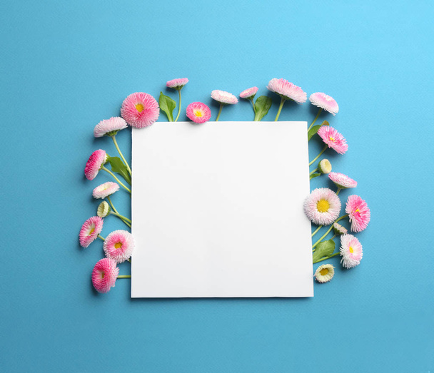 Composición plana con flores de margarita primaveral y tarjeta sobre fondo de color. Espacio para texto
 - Foto, imagen