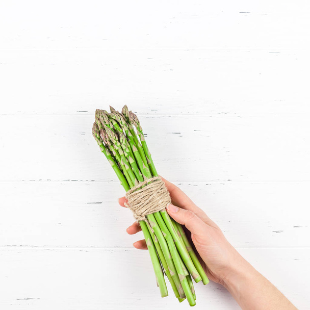Fresh green asparagus in woman hands - Foto, imagen