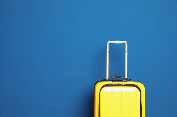 Stylish suitcase against color background, space for text - 写真・画像