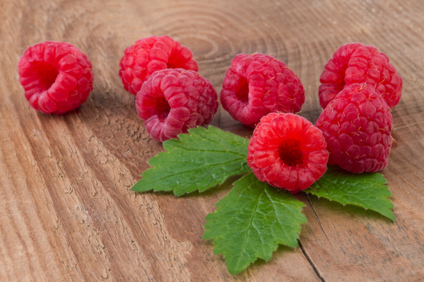 Raspberry with leafs on old wooden table - Photo, Image
