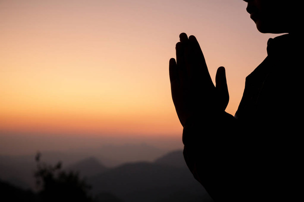 Silhouette of girl praying over beautiful sky background. Christ - Photo, Image
