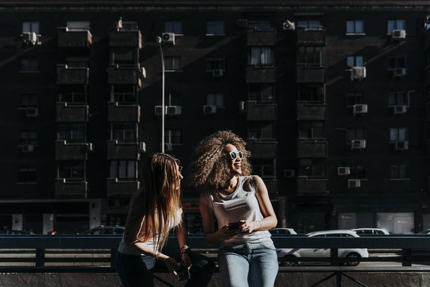 Beautiful women using a mobile in the Street. - Valokuva, kuva