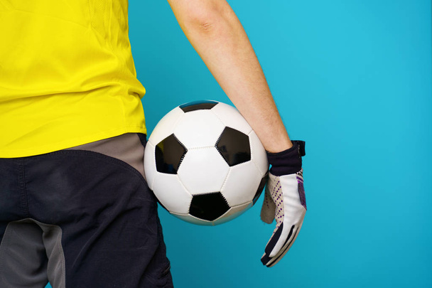 El hombre es fanático del fútbol en camiseta amarilla con pelota de fútbol
 - Foto, imagen