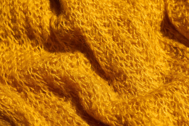 Texture of knitted fabric of yellow color. Bright yellow abstract background. Fabric mustard color. - Photo, Image