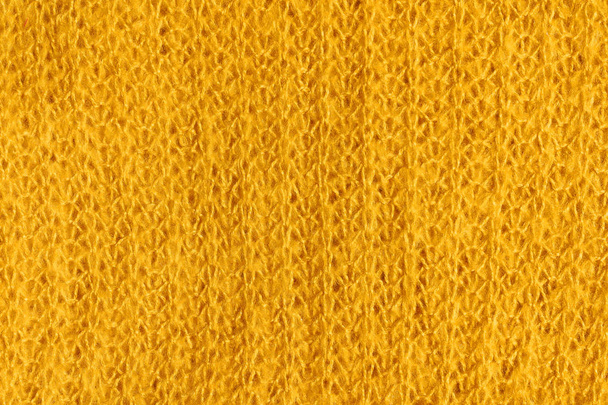 Texture of knitted fabric of yellow color. Bright yellow abstract background. Fabric mustard color. - Photo, Image