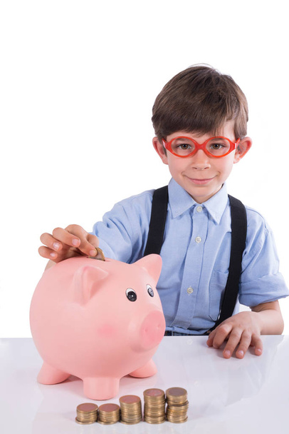 Child inserting coins into the piggy bank isolated on white - Фото, зображення