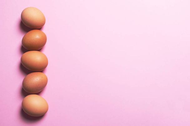 Brown eggs on pink background. - 写真・画像