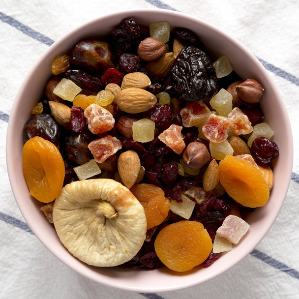 Dried fruits and nuts in a pink bowl, view from above. Overhead, - Photo, Image