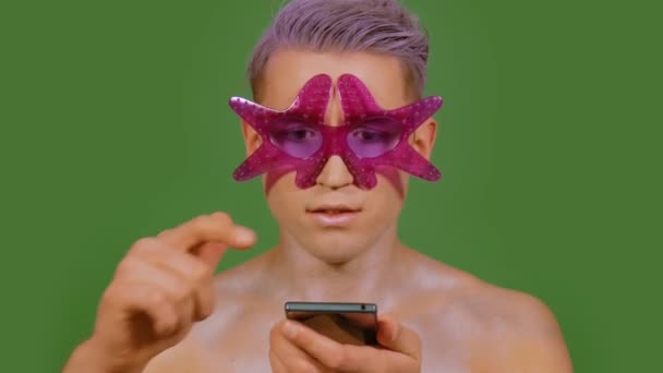 Ο άνθρωπος χρησιμοποιεί ένα τηλέφωνο σε πράσινο φόντο - Πλάνα, βίντεο