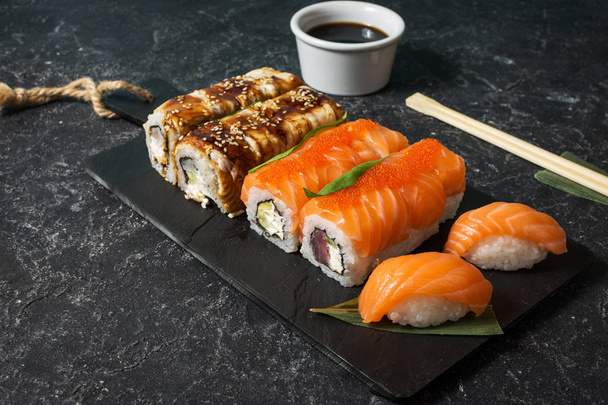 Varios tipos de sushi servidos sobre fondo de piedra
. - Foto, imagen