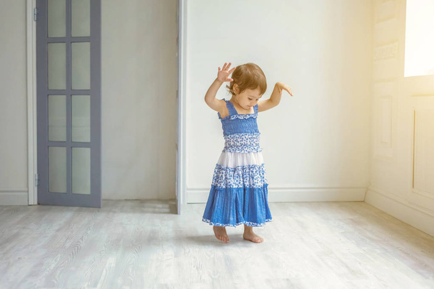 Little girl dancing in bright light living room at home and laughing - Photo, Image