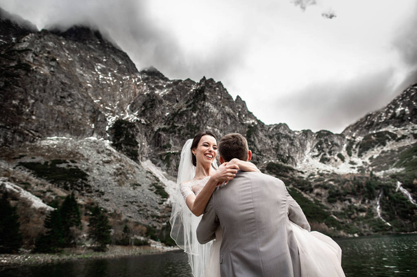 Gyönyörű esküvői photosession. A vőlegény kör fiatal menyasszonya, a parton a tó Morskie Oko. Lengyelország - Fotó, kép