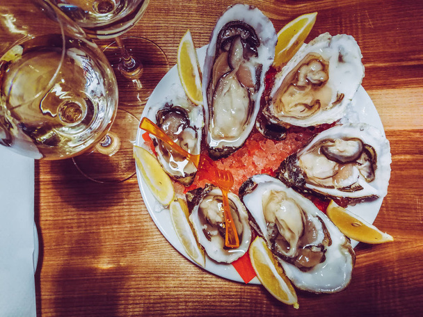 oesters met wijn op tafel - Foto, afbeelding
