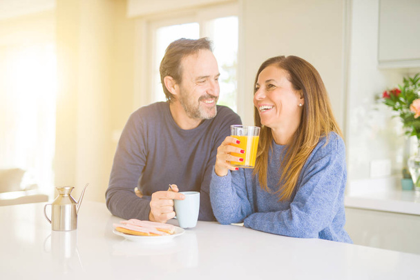 Beautiful romantic middle age couple having healthy breaskfast in the morning at home - Foto, afbeelding