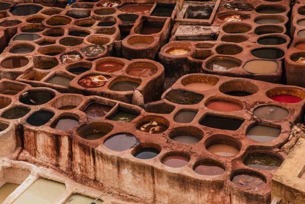 View inside of old medina in Fes, a traditional and old tannery with workers working making methods of leather in the city Fes, Morocco, in april of 2019.  - Photo, Image