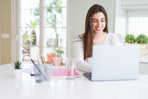 Young beautiful woman smiling happy and working using computer l - Photo, Image