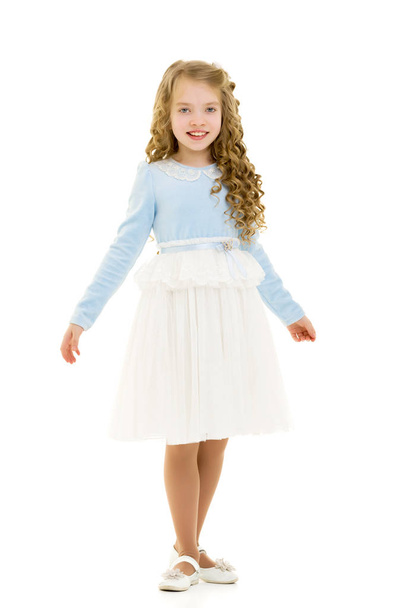 A little girl in a dress is spinning. - Zdjęcie, obraz