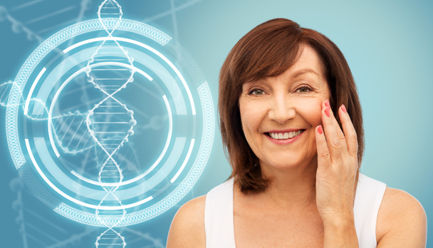 mujer mayor tocando su cara sobre la molécula de ADN
 - Foto, Imagen
