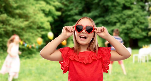 happy girl with heart shaped sunglasses at party - Fotoğraf, Görsel