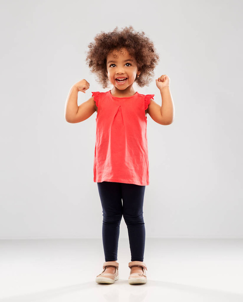 happy little african american girl showing power - Fotó, kép