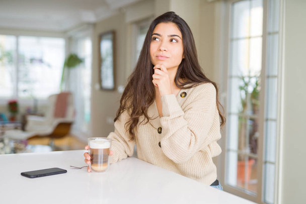 Fiatal nő iszik egy csésze kávét otthon komoly arc gondolkodás kérdés, nagyon zavaros ötlet - Fotó, kép