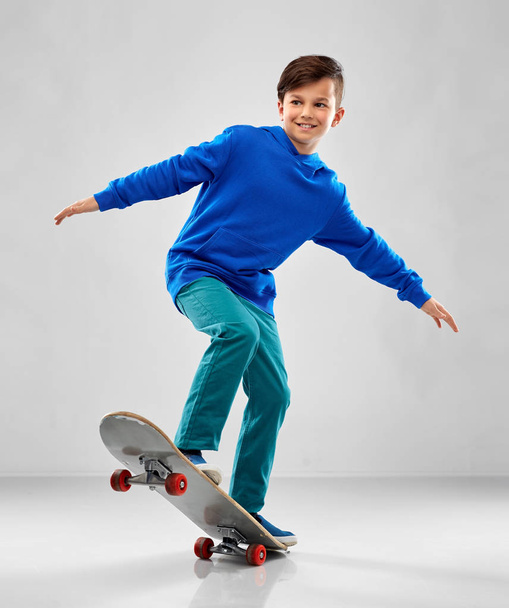 smiling boy in blue hoodie with skateboard - Fotoğraf, Görsel