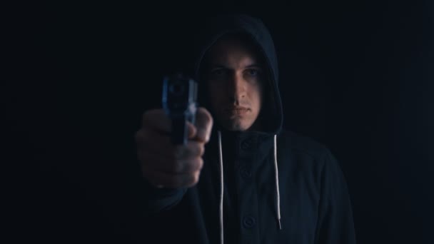 Tehlikeli kapüşonlu Suçlu siyah arka plan onun Gun hedefliyor - Video, Çekim