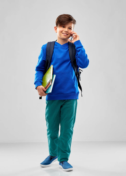 student boy with school bag calling on smartphone - Zdjęcie, obraz