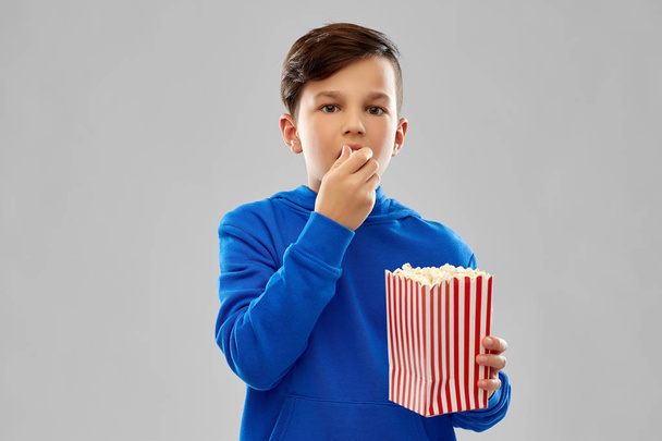 boy in blue hoodie eating popcorn - Valokuva, kuva