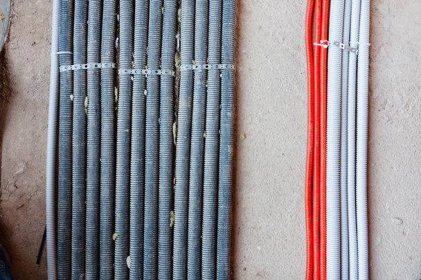 Colocación de cables eléctricos, redes, calefacción. Líneas corrugadas sobre hormigón
 - Foto, Imagen