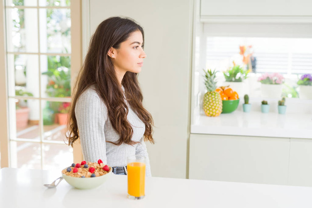 Jovem mulher tomando café da manhã saudável na parte da manhã olhando para o lado, relaxe pose perfil com rosto natural com sorriso confiante
. - Foto, Imagem