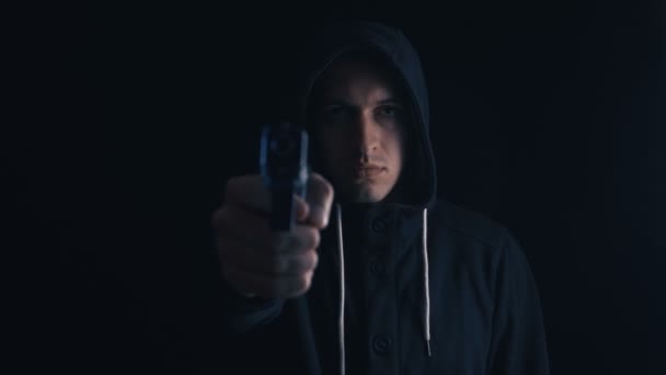 Pericoloso incappucciato Criminale mira la sua pistola su sfondo nero
 - Filmati, video