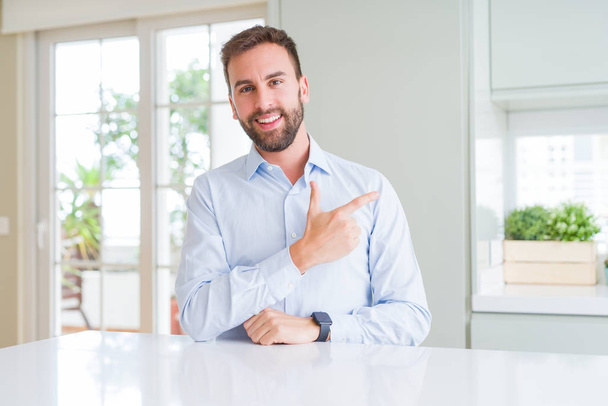 Handsome business man cheerful with a smile of face pointing with hand and finger up to the side with happy and natural expression on face - Fotoğraf, Görsel