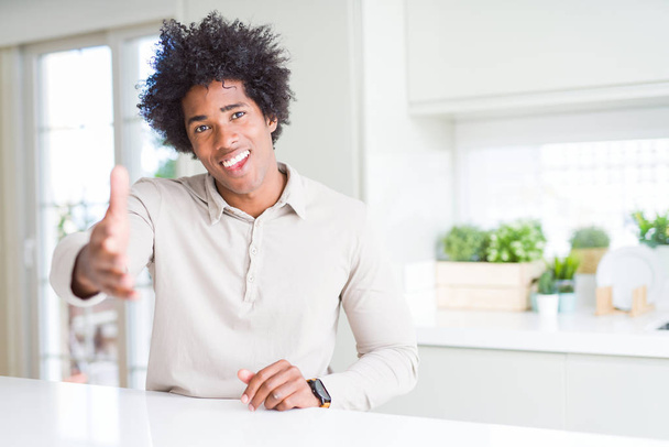 Афроамериканець людина будинку посміхаючись дружні пропонуючи рукостискання як привітання і вітаючи. Успішний бізнес. - Фото, зображення