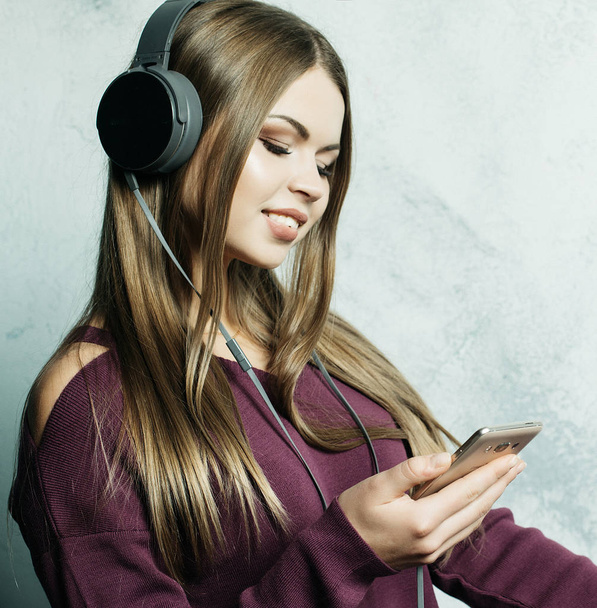 people  and technology concept - happy woman   in headphones listening to music from smartphone - Фото, зображення