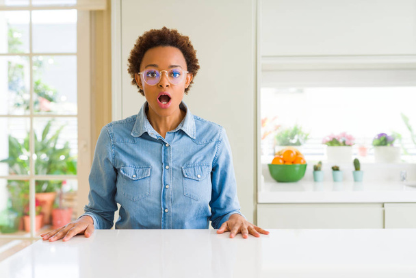 junge schöne afrikanisch-amerikanische Frau trägt Brille Angst und schockiert mit überraschtem Ausdruck, Angst und aufgeregtem Gesicht. - Foto, Bild