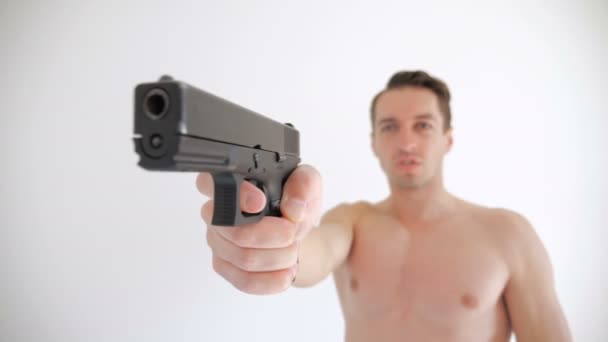 Homem nu aponta sua arma no fundo branco
 - Filmagem, Vídeo
