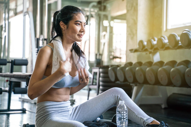 Sport vrouwen ontspannen na Weight Training houden fles water  - Foto, afbeelding