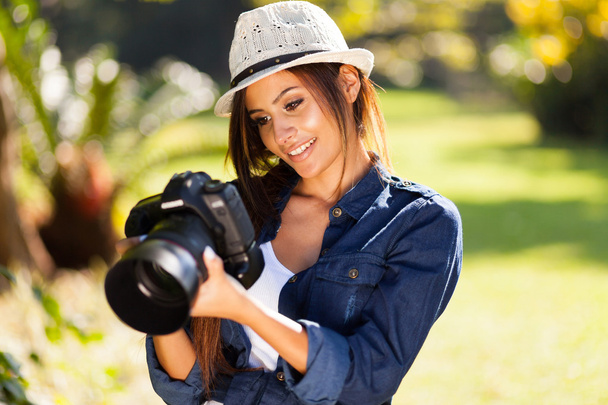 young female photographer checking pictures on camera - Foto, Imagen