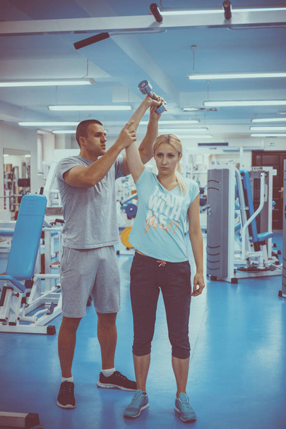 The concept of personal training. Coach and client in the gym - Photo, Image
