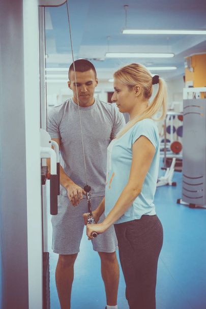 The concept of personal training. Coach and client in the gym - Foto, imagen