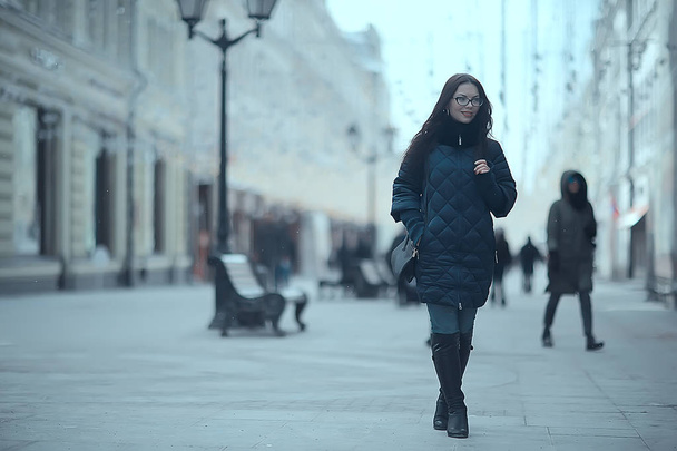 adult model girl in a coat on a winter walk in the city / Christmas vacation city tour - Zdjęcie, obraz