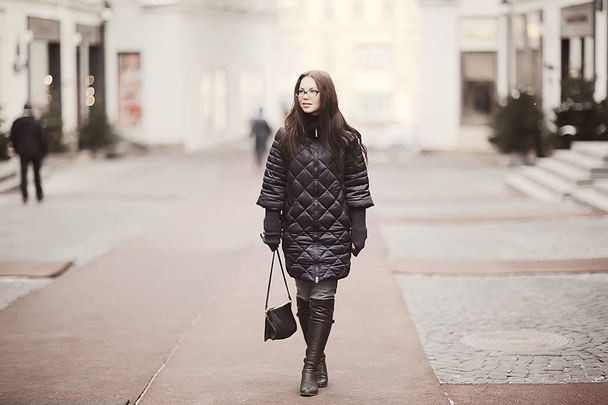 adult model girl in a coat on a winter walk in the city / Christmas vacation city tour - Фото, изображение