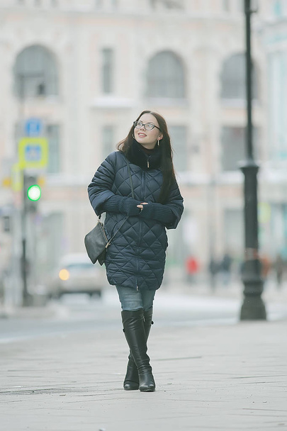 adult model girl in a coat on a winter walk in the city / Christmas vacation city tour - Photo, image