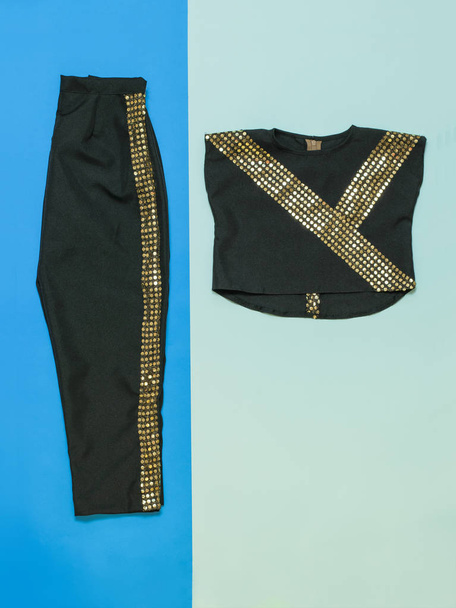 Black with gold trim dance costume on multicolored background. Flat lay. - Photo, Image