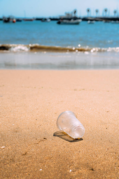 Σκουπίδια αριστερά πλαστικό κύπελλο στην παραλία κάνει ρύπανσης - Φωτογραφία, εικόνα