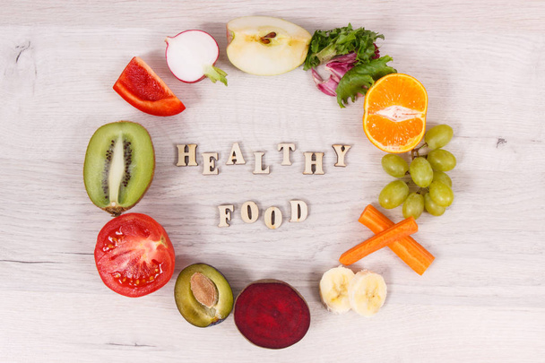 Надпись здоровое питание и питательные фрукты и овощи в качестве источника природных минералов и витаминов
 - Фото, изображение