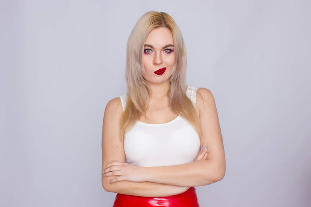 Blonde woman in red leather skirt and white shirt - Фото, изображение